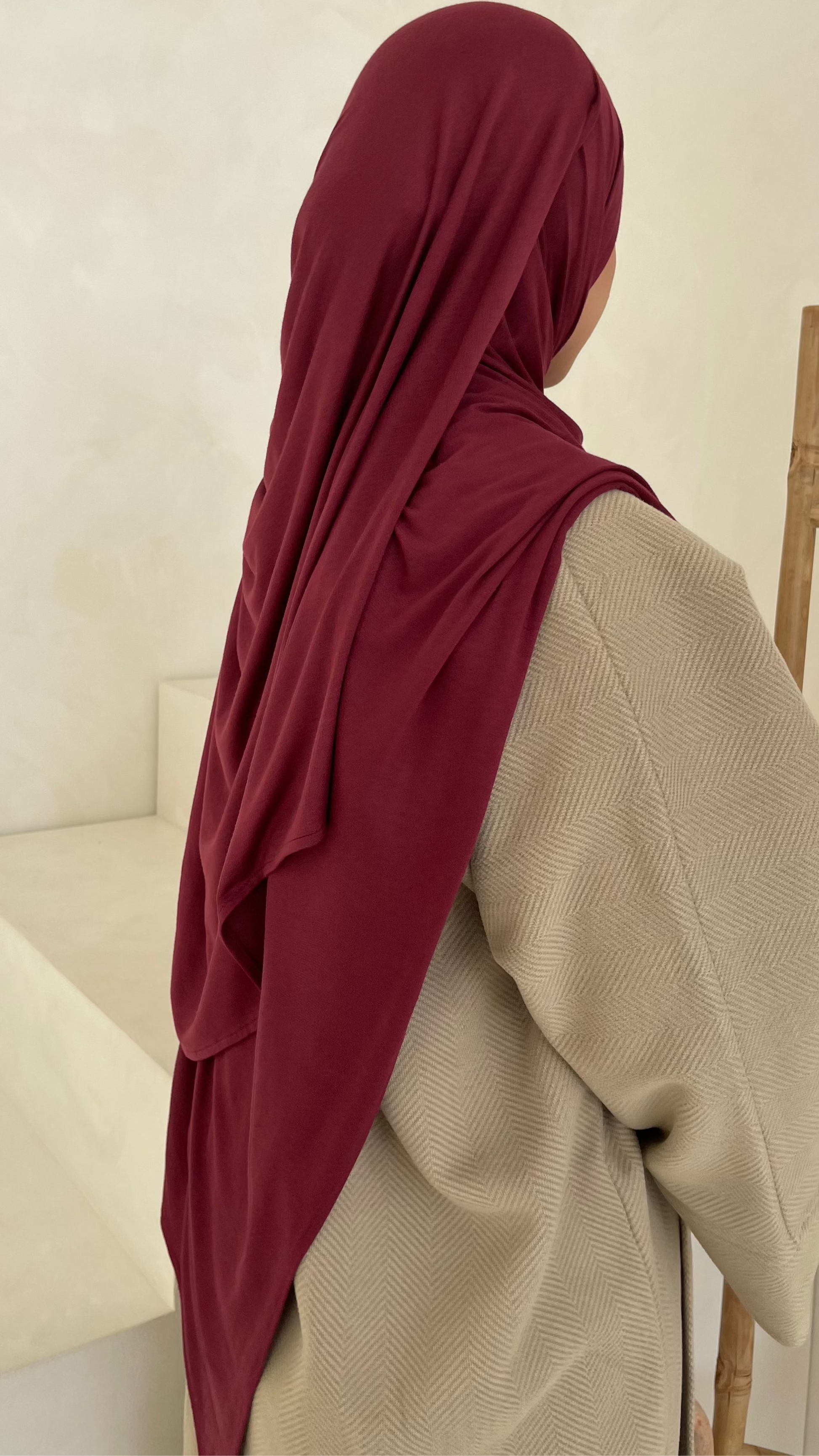 Luxury modest clothing brands. Muslim women wearing matching hijab set in burgundy maroon winter hijab styles.