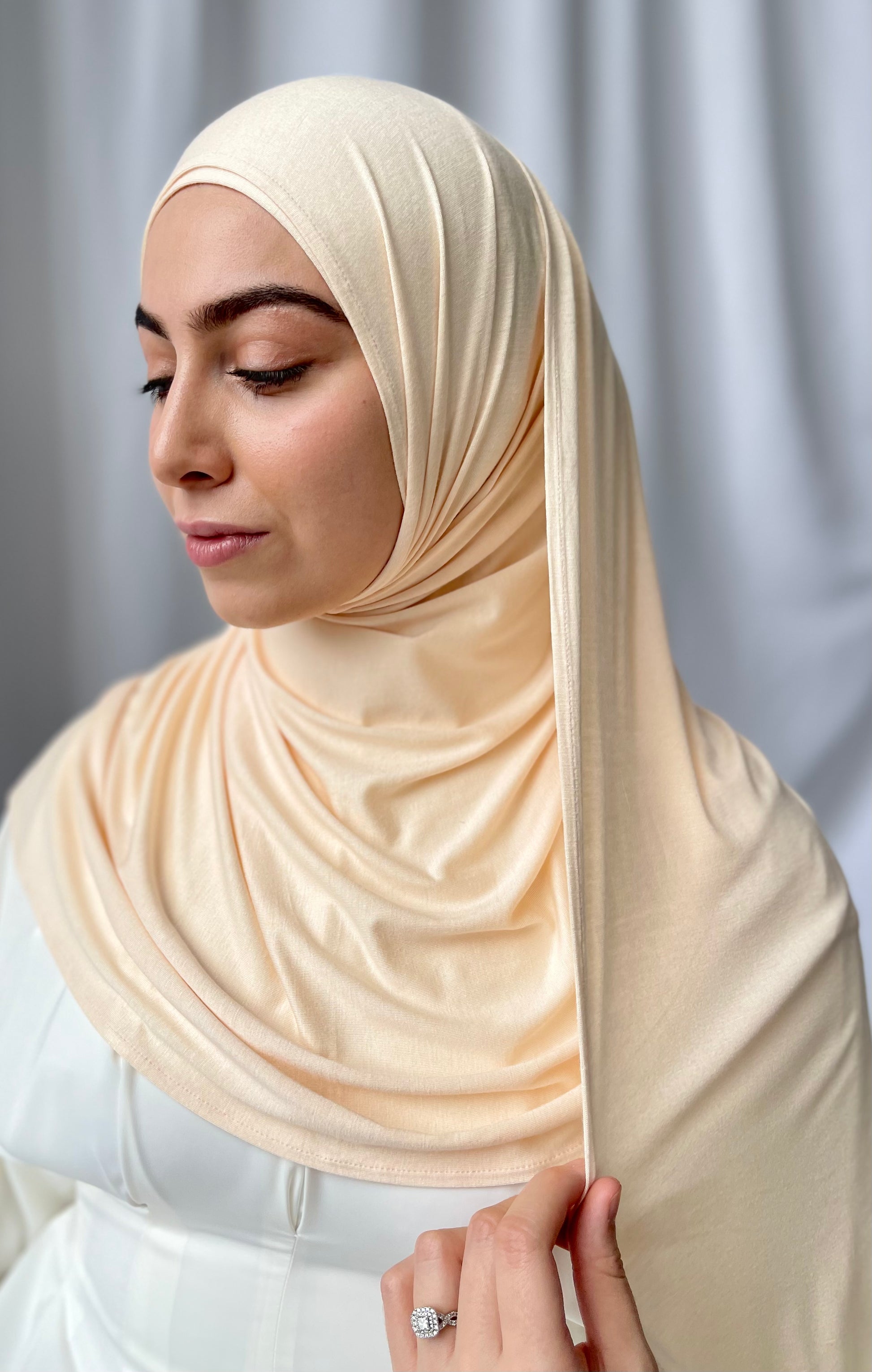 A muslim woman wearing a light beige colour hijab. Premium Jersey hijab sets UK