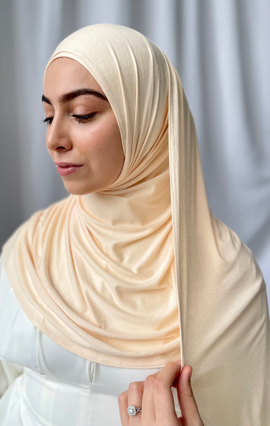 A muslim woman wearing a light beige colour hijab. Premium Jersey hijab sets UK