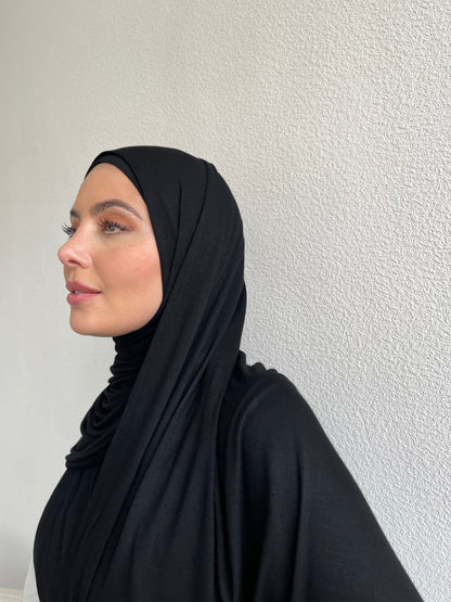 Hijabi women wearing black jersey hijab set with full coverage tie back hijab cap.