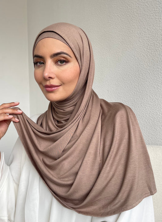 A muslim woman wearing a beige jersey hijab from hayaa the label ltd 