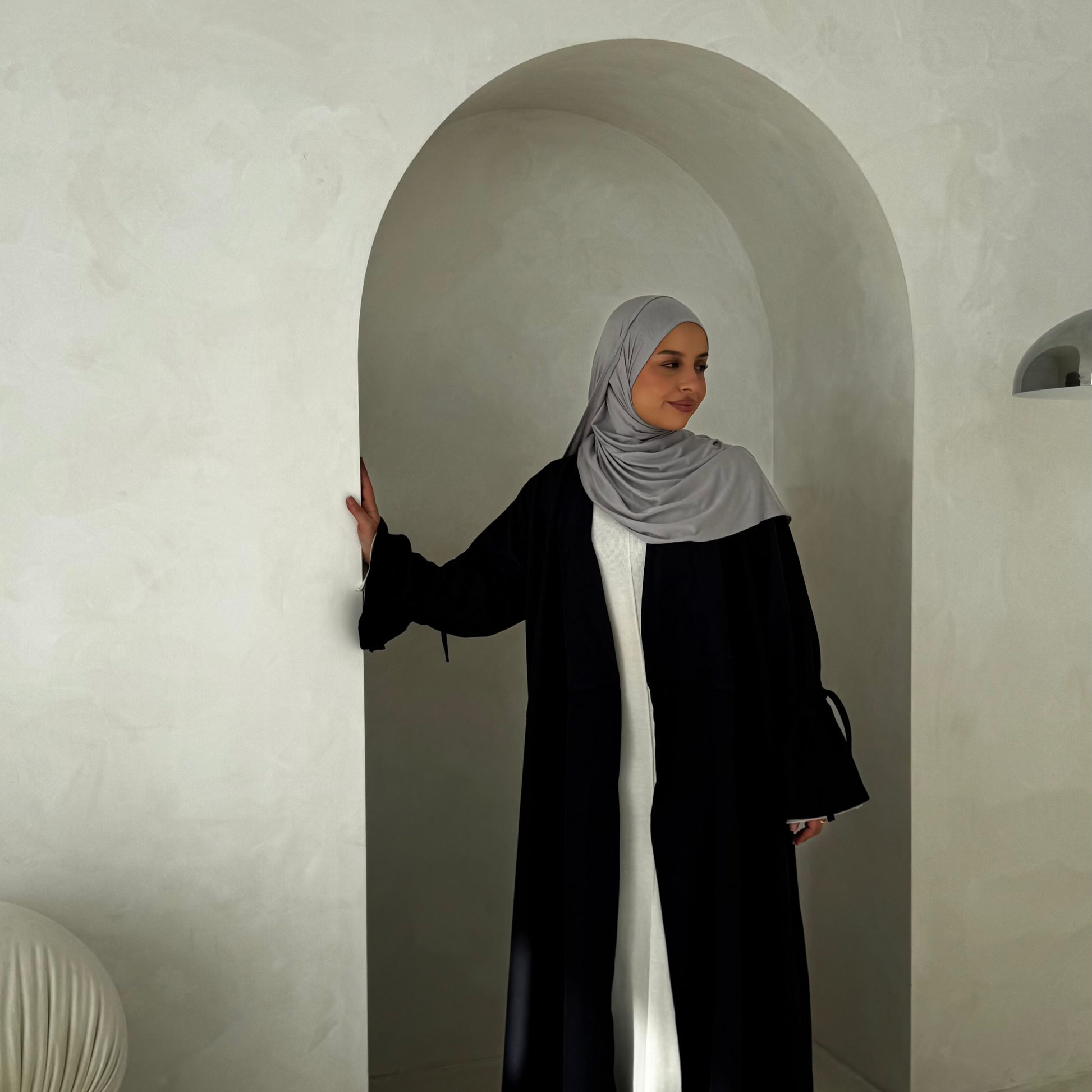A woman wearing a gray premium lightweight jersey hijab, apparel for muslim women.